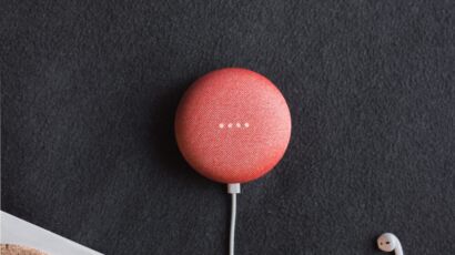 flat lay photography of coral Google Home Mini on black surface beside Apple AirPods