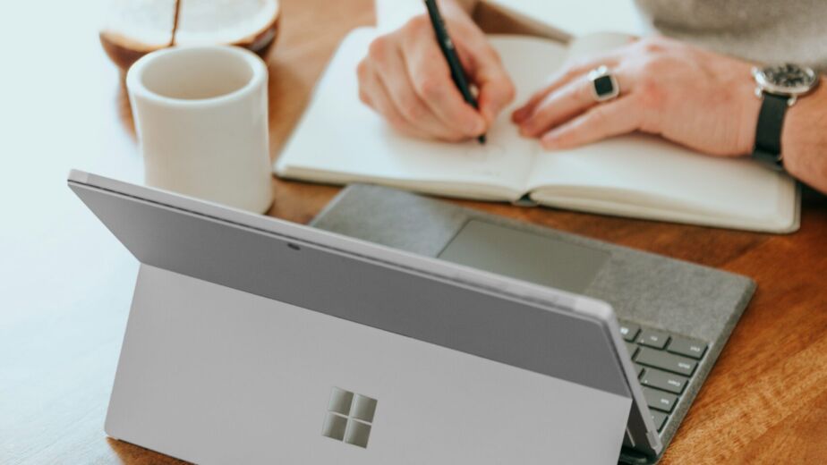 a man sitting at a table writing on a notebook