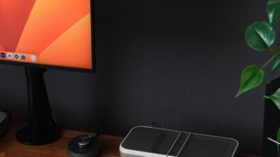 a desk with a laptop, keyboard, mouse and a monitor