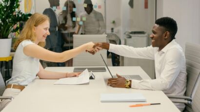 Free Business professionals completing a successful deal with a handshake in a modern office setting. Stock Photo